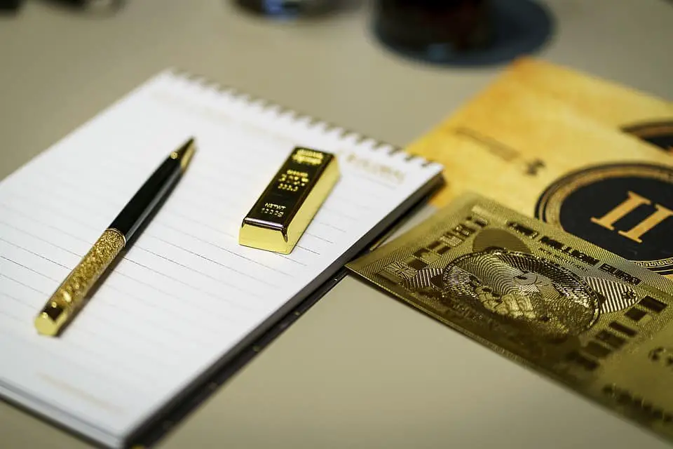 gold bar, ballpen and a notebook