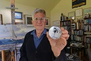 man holding a platinum coin